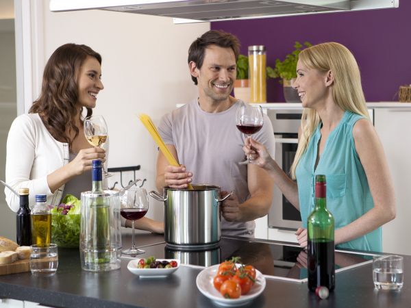 People drinking wine and cooking